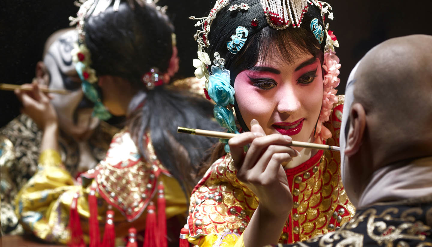 China (Volksrepublik) - Chinese opera singer applying makeup to male