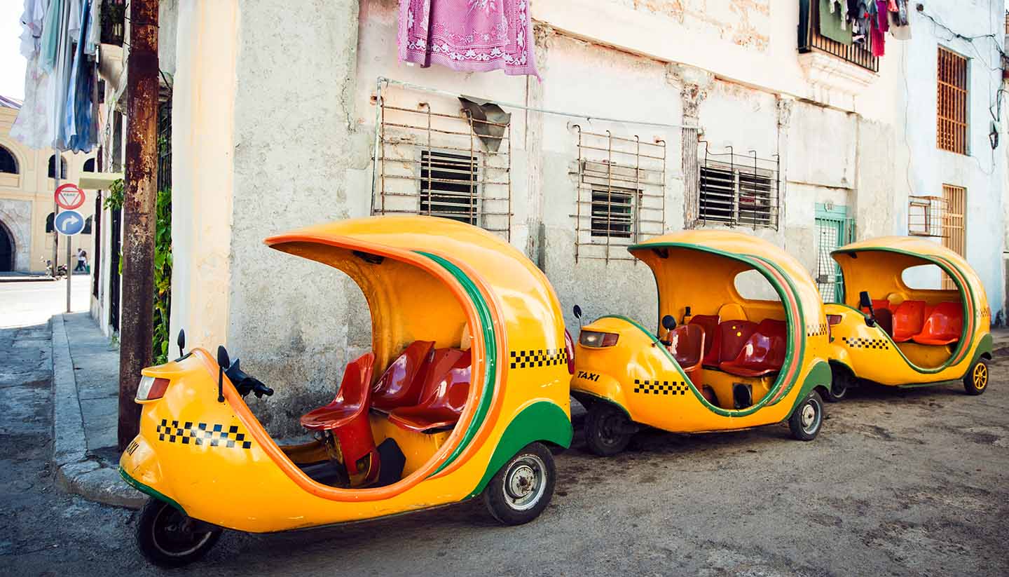 Kuba - Coco-taxis parked at a street of Havana