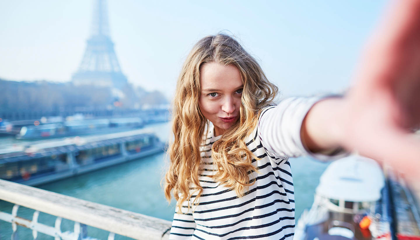 Paris - Young girl taking selfie near the Eiffel tower