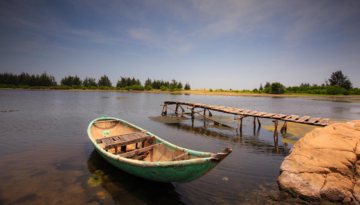 Guinea - Small pier with boat in a pond