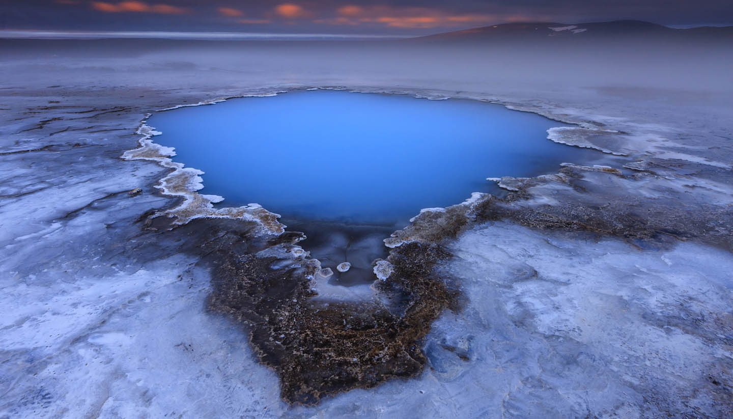 Island - Geothermal hot spring Hveravellir with mist and steam and dramatic sunrise