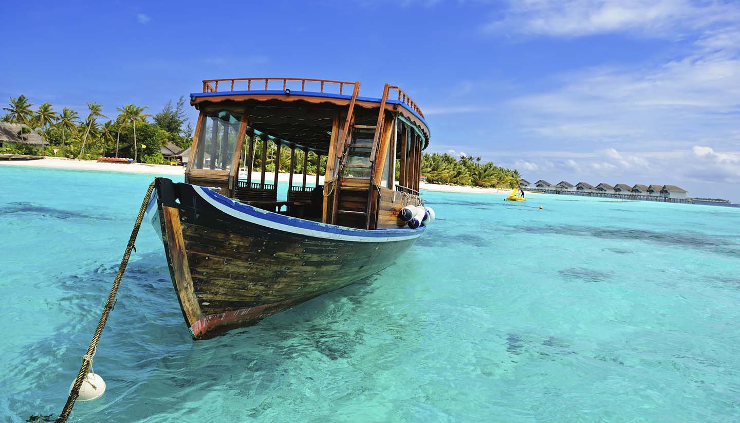 Malediven - Wooden Dhoni boat on the clearwater ocean in Maldives