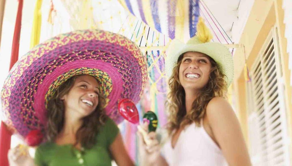 Mexiko - Smiling women with sombreros maracas