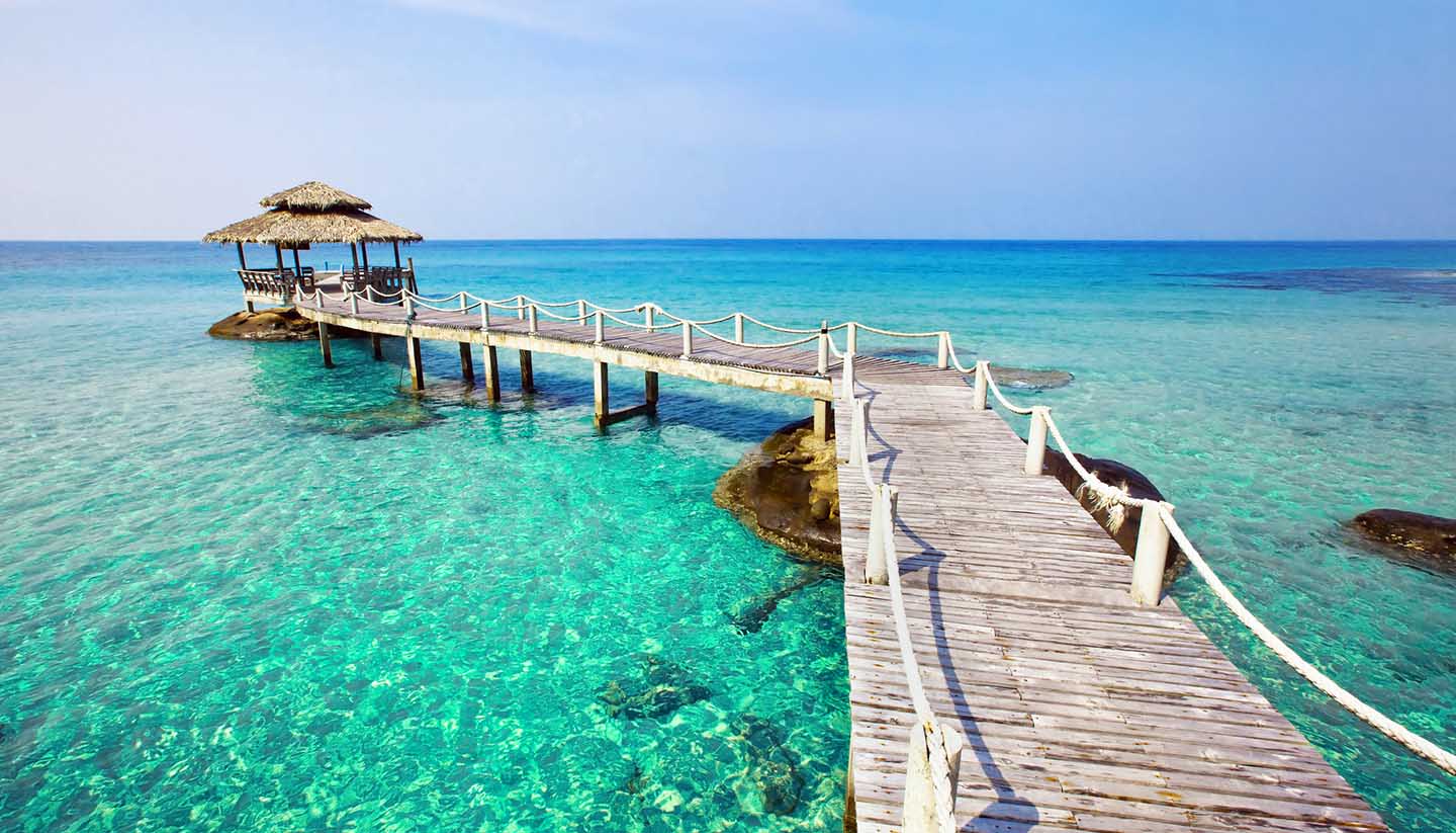 Seychellen - Pier and gazebo on clear blue water at a tropical beach