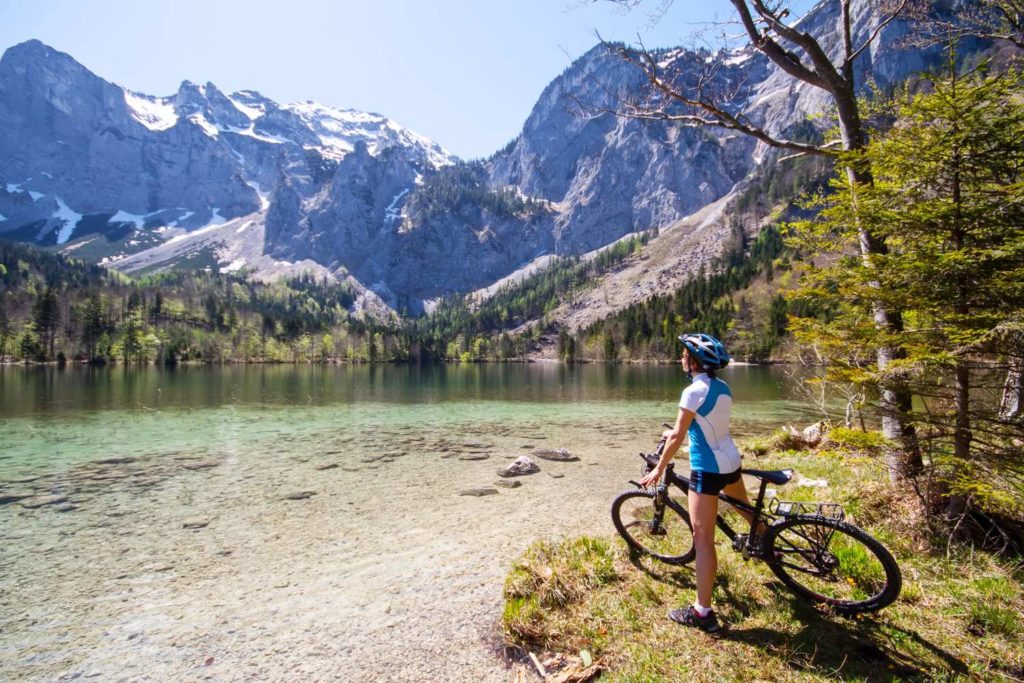 Ein Radfahrer, der einen See im Salzkammergut bewundert